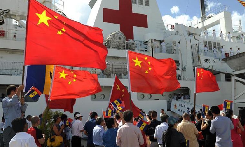 Overseas Chinese welcome the arrival of China's naval hospital ship Peace Ark at the port of Bridgetown, Barbados, Nov. 27, 2015. China's naval hospital ship Peace Ark arrived in Bridgetown on Friday for a seven-day medical service and goodwill visit. (Photo: Xinhua)