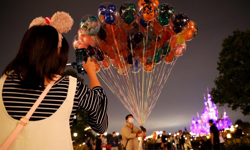 A woman takes photos of balloons at the Disneyland amusement park in Shanghai, east China, Sept. 29, 2020. (Xinhua/Fang Zhe) 
