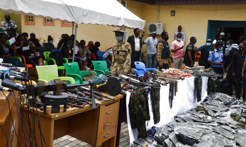 Weapons, ammunition and counterfeit military uniforms are displayed in an event showcasing Nigerian police's achievements in fighting illegal militants in Abuja, Nigeria on Sept. 30, 2020. Nigerian police have recently stepped up fight against robbers, kidnappers and illegal armed groups in different parts of the country. (Photo by David Oma/Xinhua) 