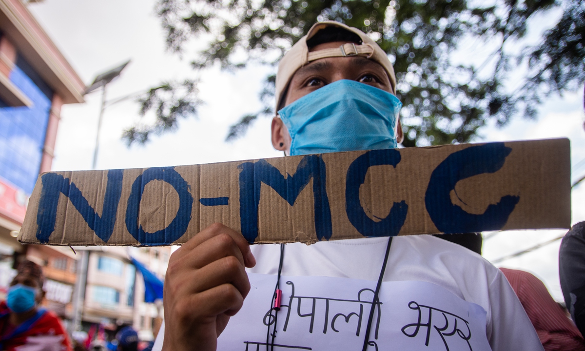 A Nepalese youth holds a cardboard sign during a protest against Millennium Challenge Corporation (MCC) programs in Kathmandu, Nepal, on June 27. Photo: AFP
