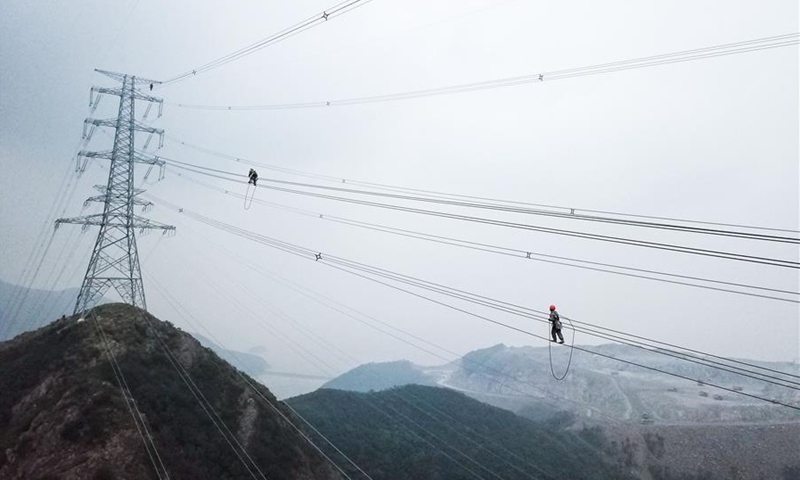 Aerial photo shows technicians of State Grid Zhejiang Electric Power Company checking power transmission lines to make sure the stable operation of local power supply in Zhoushan, east China's Zhejiang Province, Oct. 23, 2020. (Xinhua/Xu Yu) 