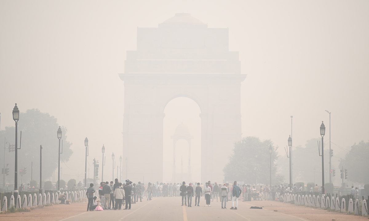 People walk along Rajpath near India Gate under heavy smog conditions in New Delhi, India on Monday. The capital's air quality has remained severe for the fifth consecutive day, with calm wind speed exacerbating the effect of stubble burning. The city's average air quality index stood at 469 at 9 am on Monday. Photo: AFP