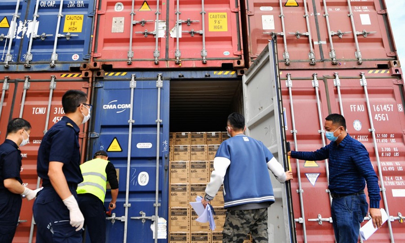 Staff members check the cargo bound for Hamburg of Germany at a cargo distribution centre in Haicang District of Xiamen, southeast China's Fujian Province, Nov. 13, 2020. (Xinhua/Wei Peiquan)