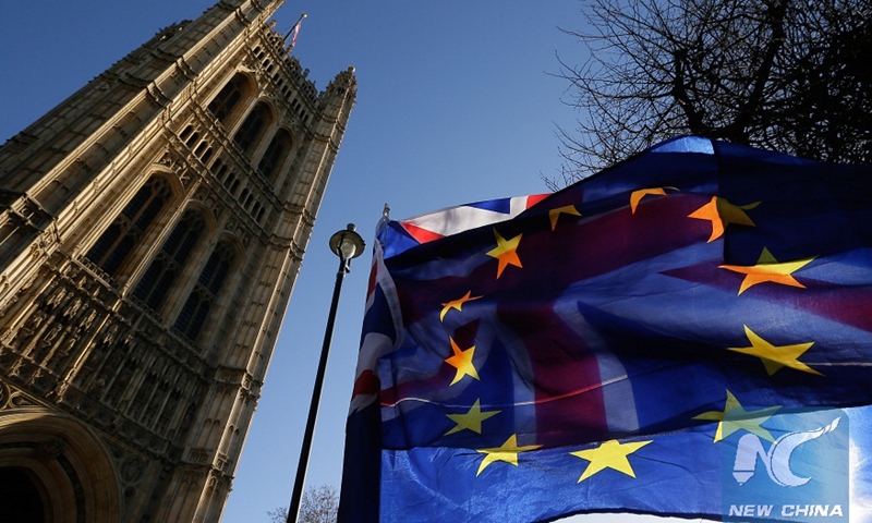 An EU flag is seen in front of a UK flag outside the Houses of Parliament in London, Britain, on Jan. 17, 2019.File photo:Xinhua