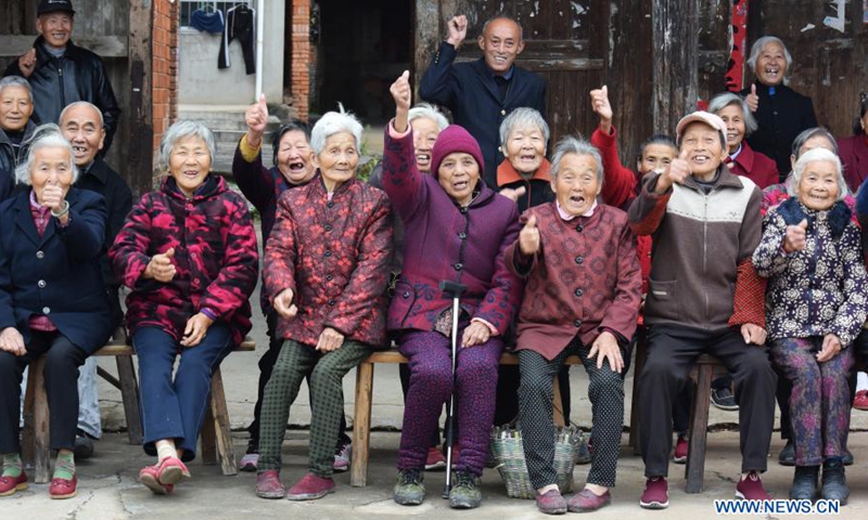Villagers pose for a group photo in Shangwei Village of Youlan Town, Nanchang City, east China's Jiangxi Province, Nov. 22, 2020. Since 2014, volunteers from a non-profit organization in Nanchang City have kept on taking photos of smiling faces of farmers aged over 70 years old in nearby villages. The portait photos taken by volunteers were given to farmers for free. By far, the volunteers have taken nearly 4,350 people and 50,000 photos. They aim at collecting high-definition images of 10,000 farmers within 10 years. (Xinhua/Chen Chunyuan)

