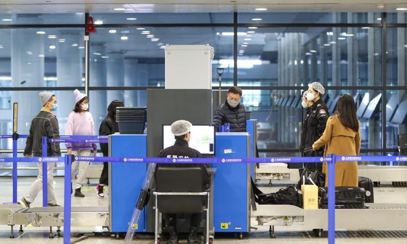 Passengers pass security checkpoint at Terminal 2 building of the Shanghai Pudong International Airport in east China's Shanghai, Nov. 24, 2020. The airport's recent daily throughput maintains at around 1,000 flights, with passengers wearing face masks and orderly moving in and out. (Xinhua/Ding Ting)