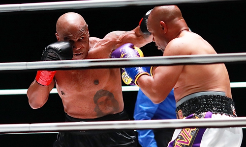 Mike Tyson (left) throws a punch in the third round against Roy Jones Jr on Saturday in Los Angeles, California. Photo: VCG