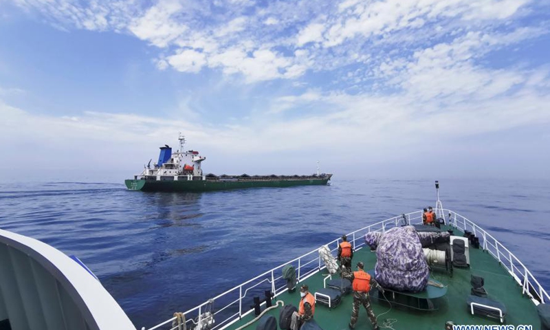 Photo taken with mobile phone on March 26, 2020 shows a vessel of the coast guard intercepting a vessel suspected of smuggling at sea. Chinese coast guard authority has dismantled more than 10 major criminal gangs engaged in illegal sea-related activities in the past three years. China's coast guards at all levels have launched campaigns and investigated more than 190 tip-offs, arresting more than 140 suspects, said the authority. (Photo by Zhai Shaohua/Xinhua)

