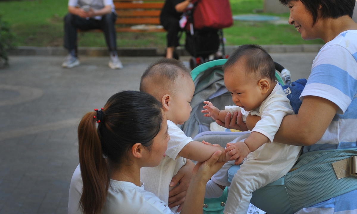 Parents holding their children play in the square of a residential community in Nanjing, capital of East China's Jiangsu Province. Photo: VCG