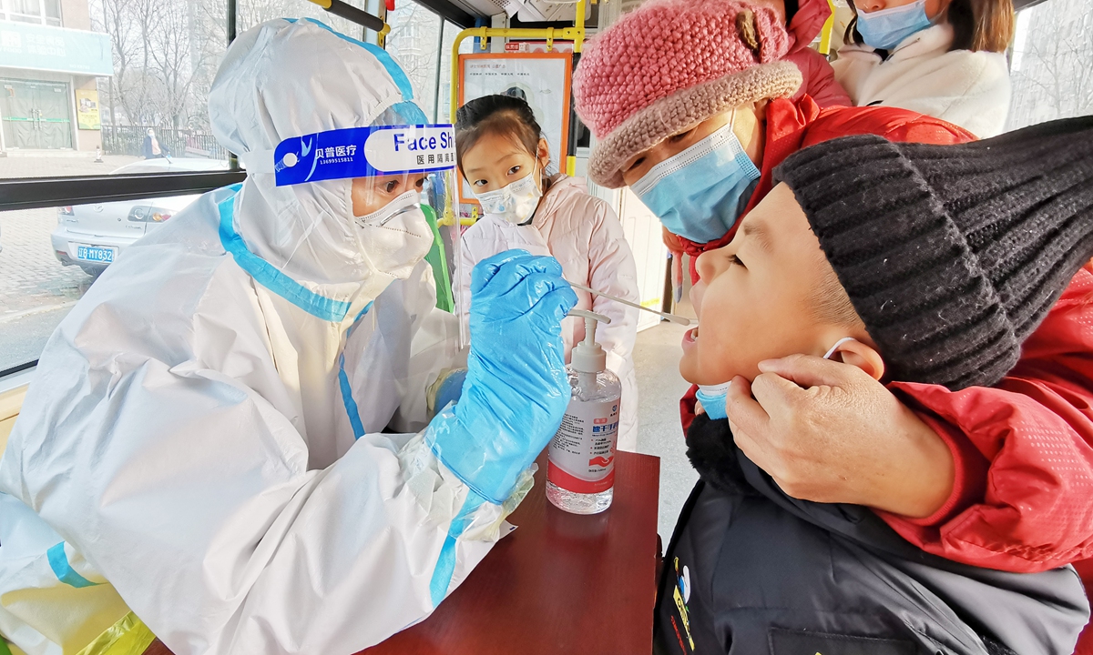 A medical worker conducts a nucleic acid test on a boy in Dalian, Northeast China's Liaoning Province on Wednesday. Dalian launched a citywide testing on Tuesday in response to a resurgence of COVID-19. On Wednesday, one new confirmed case and eight asymptomatic patients were reported in the city. Photo: VCG