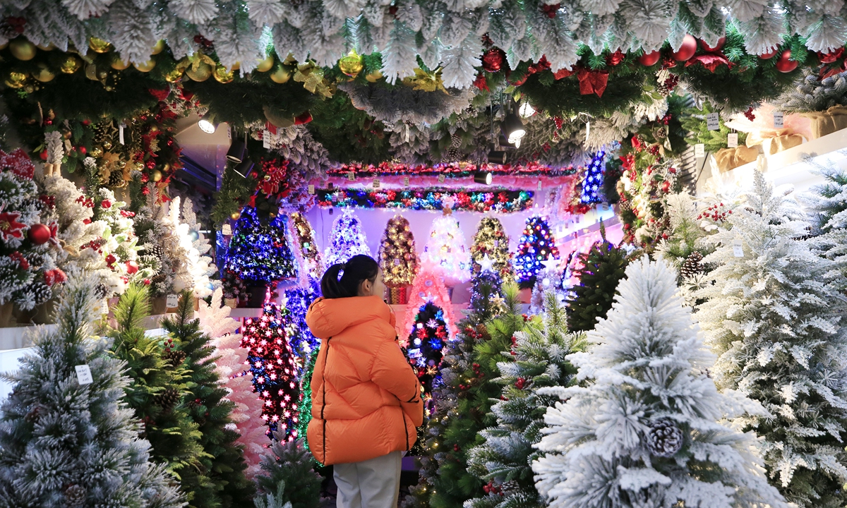 A customer buys Christmas trees at Yiwu International Trade City, East China's Zhejiang Province on December 11. Photo: Yang Hui/GT