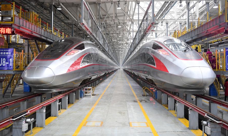 Fuxing bullet trains CR400AF make debut at a maintenance station of the railway car depot in west China's Chongqing Municipality, Dec. 23, 2020. Fuxing bullet train CR400AF, assigned to Chongqing Railway for the first time, made debut in Chongqing on Wednesday, expected to start operation Thursday with the service from Shapingba Station in Chongqing to Chengdu East station in Chengdu of west China's Sichuan Province. The trip between the two cities will be shortened from 78 minutes to 62 minutes. (Xinhua/Tang Yi)