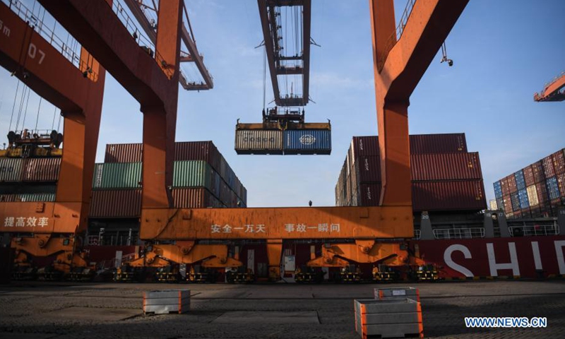 Photo taken on Dec. 28, 2020 shows containers being handled at the Qinzhou Port in south China's Guangxi Zhuang Autonomous Region. The five millionth twenty-foot equivalent unit (TEU) containers in 2020 was handled at the Qinzhou Port area of the Beibu Gulf Port on Monday, marking the Beibu Gulf Port's container throughput reaching 5 million TEUs this year. The Beibu Gulf Port currently has 268 berths for commercial vessels. A total of 52 shipping routes link the gulf with many ports both at home and abroad, including major ASEAN ports, according to the Beibu Gulf Port Group. (Xinhua/Zhang Ailin)