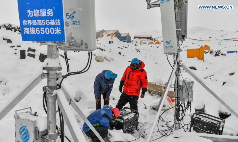 Staff members of China Mobile test the signals of the 5G base station built at an altitude of 6,500 meters at the advance camp of Mount Qomolangma in southwest China's Tibet Autonomous Region on May 21, 2020. Today, 5,417 villages, or 99 percent of all villages in the region, have 4G network coverage, and 5,439 villages have fiber-optic network connections. Aided by broadband and 4G coverage, mobile Internet is transforming the way of life on the plateau. E-commerce is booming, generating new avenues of income for Tibetans. (Xinhua/Jigme Dorje)