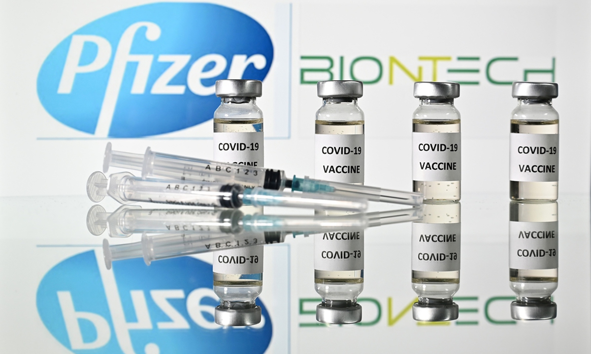 An illustration shows vials of a COVID-19 vaccine and syringes with the logos of US pharmaceutical company Pfizer and German partner BioNTech. Photo: AFP