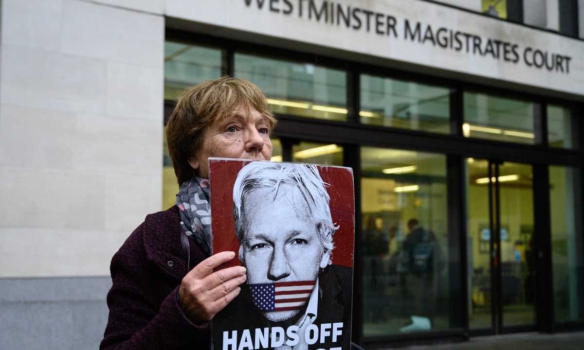 A supporter of Julian Assange holds a placard as she stands outside Westminster Magistrates Court during a hearing into Assange's ongoing extradition case, in London, Britain on November 10, 2019. Photo: VCG