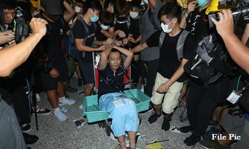 Hong Kong rioters tied Global Times reporter Fu Guohao to an airport trolley and beat him after falsely claiming he was a fake reporter. File Photo: AFP