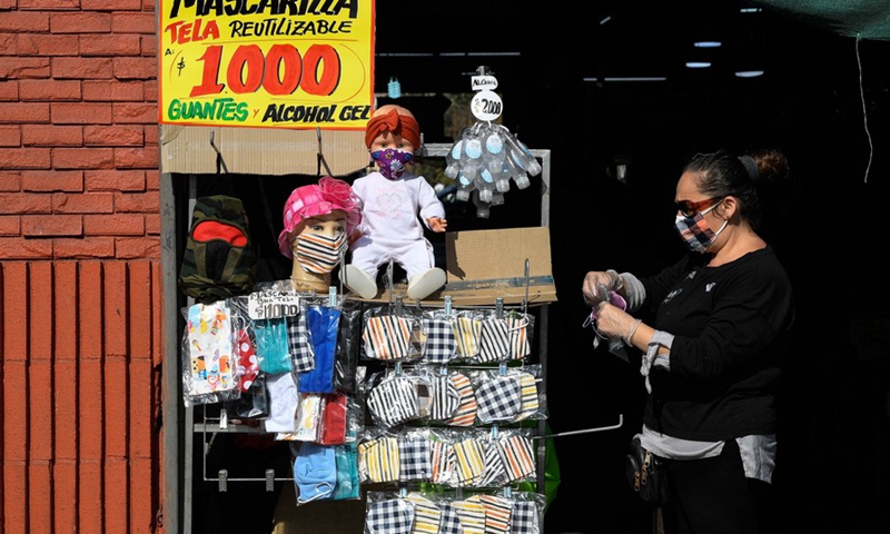 A vendor sells face masks at a market in Santiago, Chile, April 16, 2020. (Photo by Jorge Villegas/Xinhua)