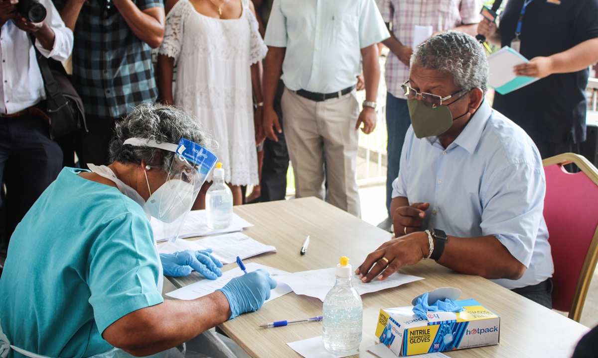 President of Seychelles Wavel Ramkalawan (right) answers a practitioner prior to receive the first dose of the Chinese COVID-19 vaccine produced by Sinopharm at the Seychelles Hospital in Victoria Sunday. More than 1.9 million people worldwide have now died from the virus, with new variants adding to soaring cases and prompting the re-introduction of restrictions on movement across the globe. Photo: AFP