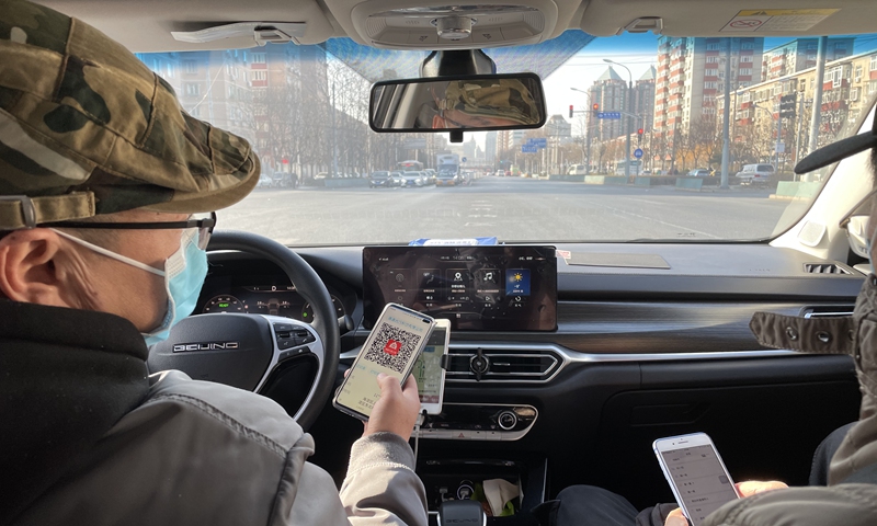 A passenger scans a health code provided by a car-hailing driver in Beijing on Monday, the first day that Beijing required car hailing services to register the health codes of passengers. Photo: Liu Caiyu/GT