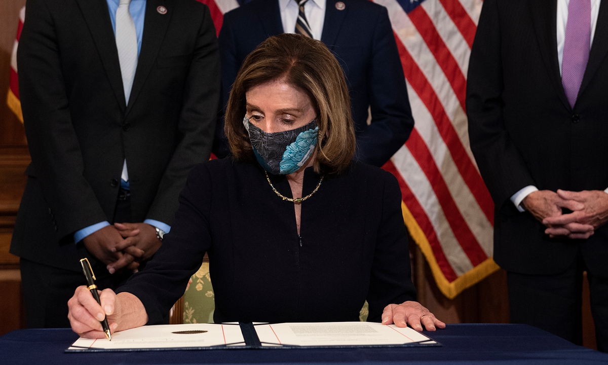 Speaker of the House Nancy Pelosi signs the article of impeachment alongside impeachment managers after the US House of Representatives voted to impeach US President Donald Trump, at the US Capitol on Wednesday, in Washington, DC. Photo: AFP