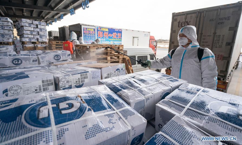 A staff member sprays disinfectant on the package of imported cold chain food at a regional cold chain center in Wuhan, capital of central China's Hubei Province, Jan. 7, 2021. (Xinhua/Xiong Qi)

