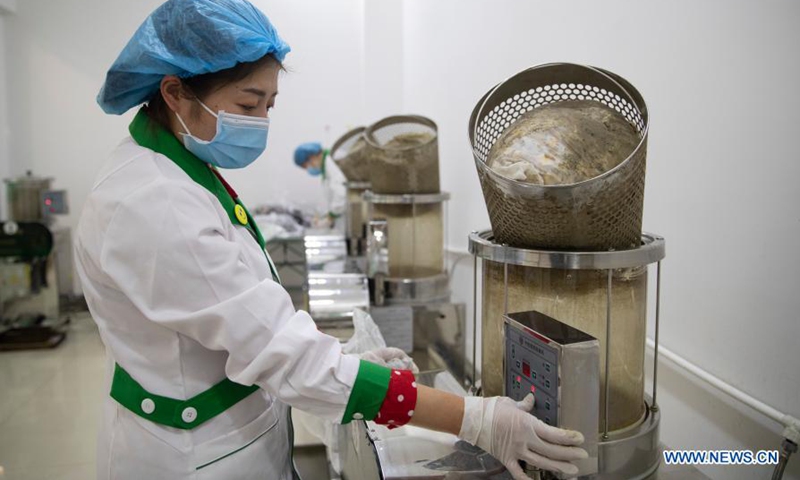 A pharmacist makes the herbal decoction of the Traditional Chinese medicine (TCM) at a pharmacy in Suihua, northeast China's Heilongjiang Province, Jan. 25, 2021. (Photo by Zhang Tao/Xinhua)