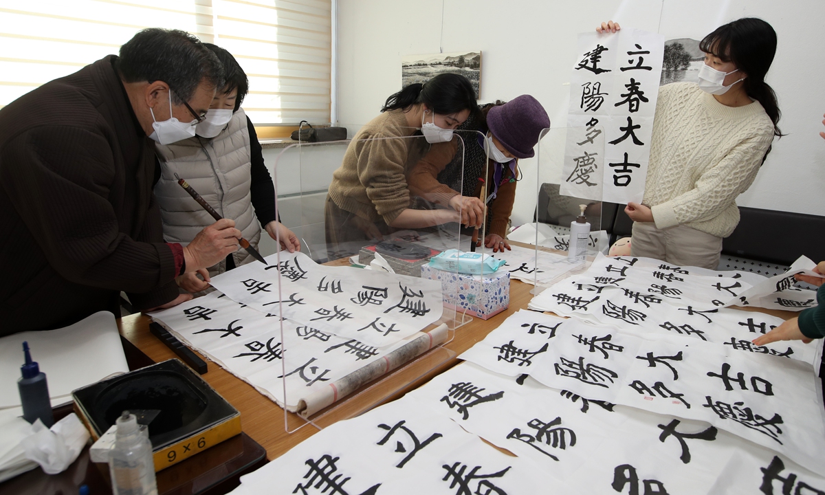 The elderly and the staff members of a nursing home in Gwangju's Buk (North) District, South Korea practice calligraphy together on Wednesday. Photo: AFP