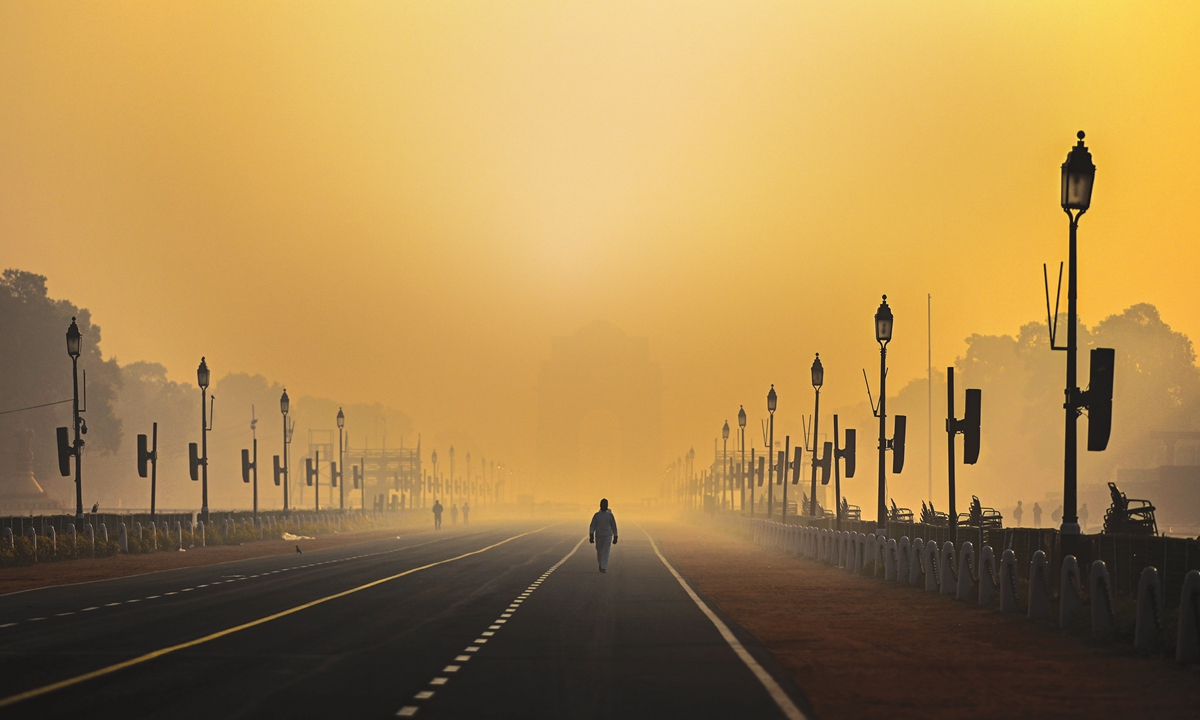 A man walks along Rajpath in smog in New Delhi on Thursday. The capital city of India continued to experience dense fog on Thursday with air quality in the 
