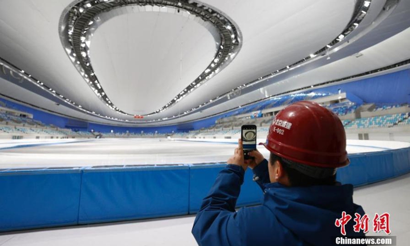 Photo shows a construction worker taking photos at the National Speed Skating Oval in Beijing, capital of China, Jan. 28, 2021. The ice-making work at the National Speed Skating Oval in Beijing, also known as the Ice Ribbon, was completed, meaning the iconic venue for the 2022 Winter Olympics is now ready for test competitions.Photo:China News Service