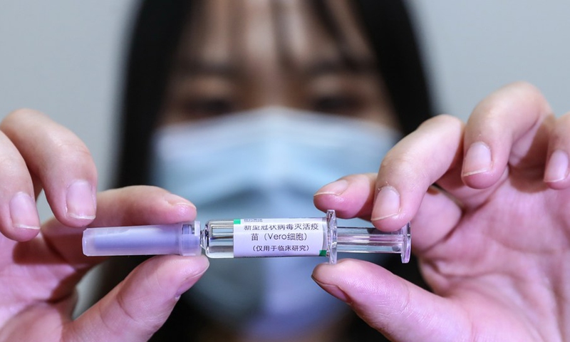 A staff member displays a sample of the COVID-19 inactivated vaccine at a vaccine production plant of China National Pharmaceutical Group Co., Ltd. (Sinopharm) in Beijing, capital of China, April 10, 2020. (Xinhua/Zhang Yuwei)