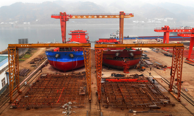 Workers build large cargo ships in Yichang, Central China's Hubei Province on Sunday. In 2020, the output value of Yichang's shipbuilding industry, hit by the epidemic for almost half a year, reached 9 billion yuan ($1.4 billion). It was also the fourth year in which the industry built more than 100 ships, holding first place in Hubei Province. Yichang has become a shipbuilding center in the middle and upper reaches of the Yangtze River. Photo: cnsphoto 