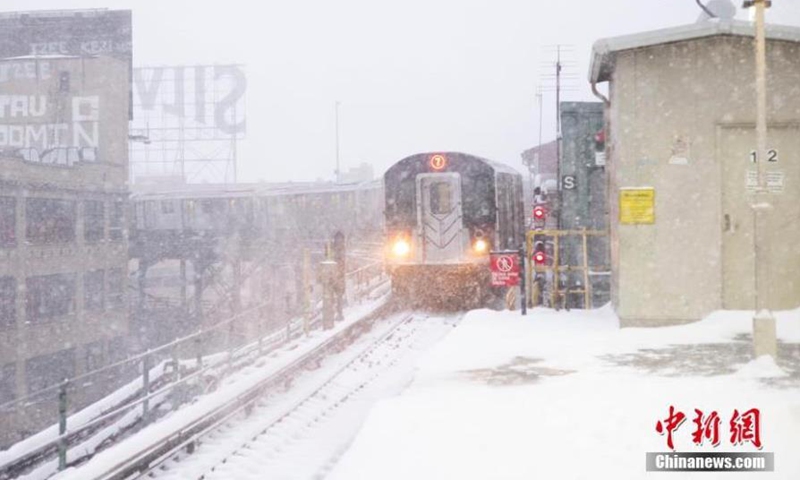 A Metro train approaches a station as a nor'easter blanketed much of New York State with snow on Feb. 1, 2021. New York State declared a state of emergency in New York City, Long Island and seven counties in Hudson Valley on Monday as a heavy snowstorm has been hitting the areas hard from Sunday night. (Photo/China News Service)