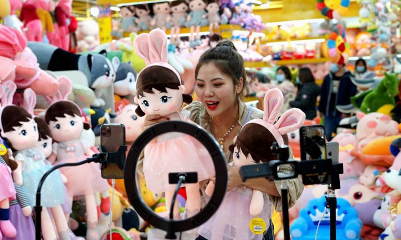 A saleswoman promotes stuffed toys via livestreaming at an international trading center in Baigou New Township, Baoding City of north China's Hebei Province, Feb. 2, 2021. Traders in the Baigou New Township have launched an on-line shopping event for the upcoming Chinese Lunar New Year, where price discounts, electronic coupons, and purchase subsidies are offered to attract more buyers for their commodities such as suit cases, garments, and stuffed toys. (Photo by Feng Yun/Xinhua)

