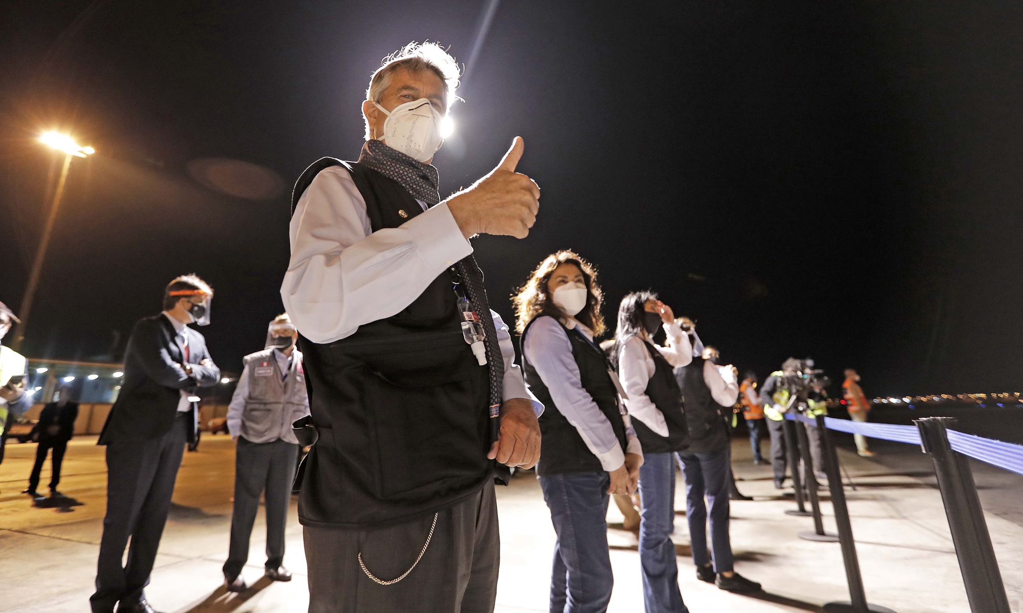 A handout photo provided by the Peruvian presidency shows President Francisco Sagasti (front) reacting during the arrival of the Air France plane with the first batch of COVID-19 vaccine at the Jorge Chavez airport in Lima, Peru on Sunday.  Peru received its first 300,000 vaccines amid a critical oxygen shortage due to a spike in COVID-19 cases. Photo: IC