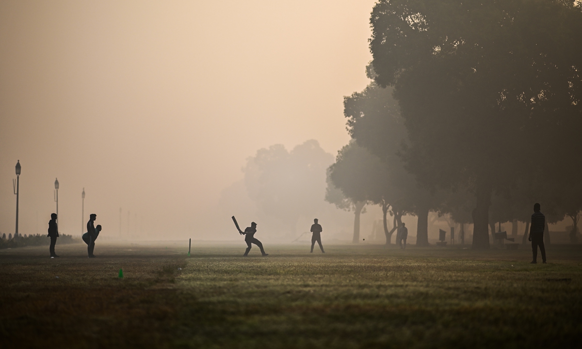 People play cricket at a park amid smoggy conditions in New Delhi, India on Monday. Photo: AFP