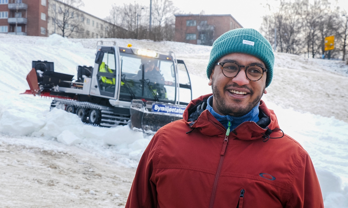Oslo city councilor Omar Samy Gamal poses for a photo as a snow plough prepares a snowboarding hill in the Torshovdalen park in Oslo, Norway on February 10. Photo: AFP