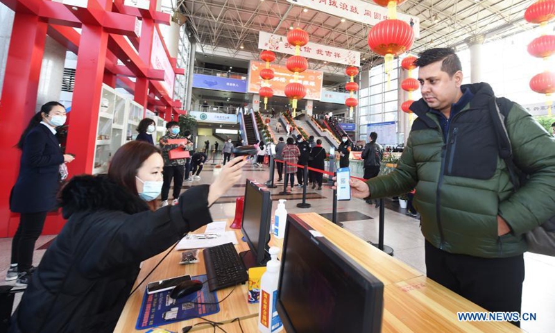 A foreign merchant shows his QR code at the Yiwu International Trade Market in Yiwu City, east China's Zhejiang Province, Feb. 20, 2021. Markets in Yiwu, China's small commodities trade hub, reopened to customers Saturday after the Spring Festival holidays. (Photo by Gong Xianming/Xinhua)