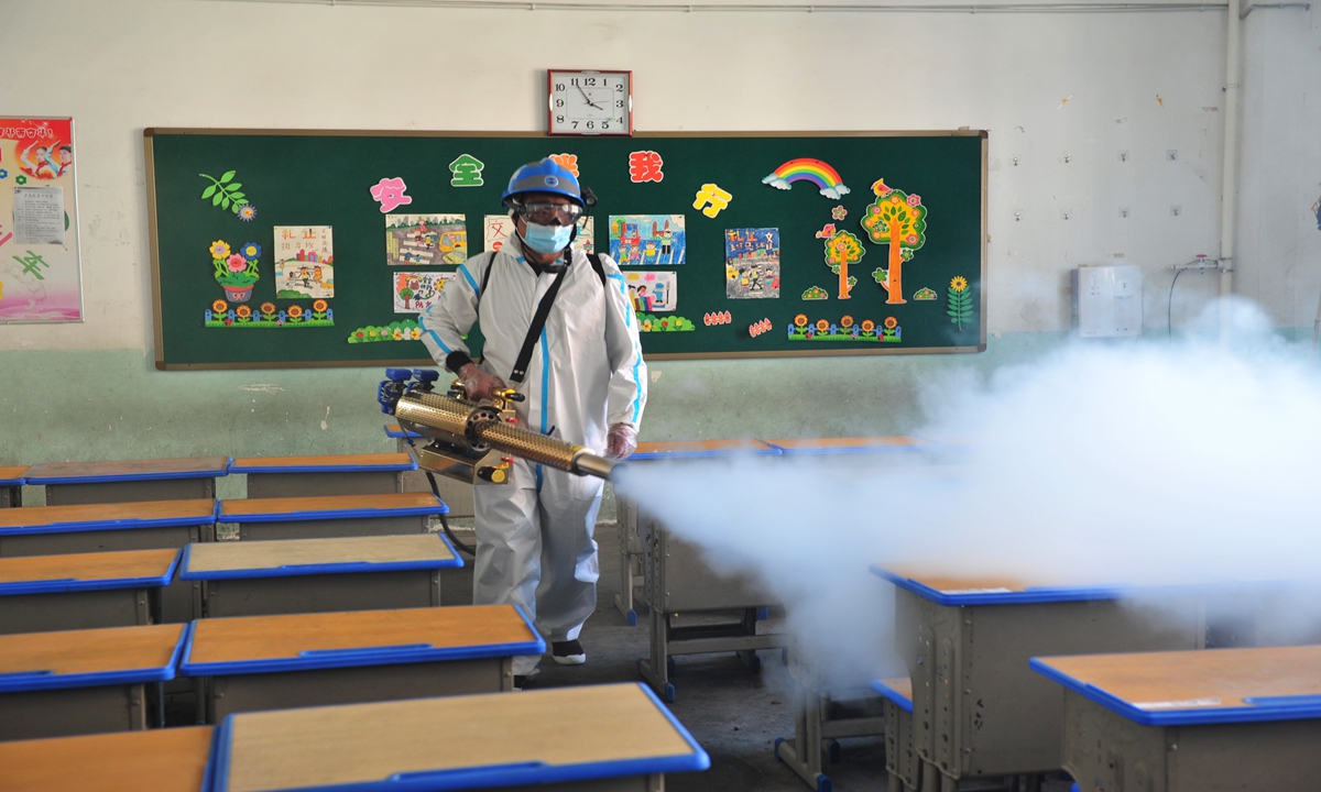 A voluntter from the Blue Sky Rescue Team disinfects a classroom in a school in Suining, East China's Jiangsu Province, on Monday. The team is working with the local education authority to disinfect schoolrooms before the new semester starts on Monday. 
