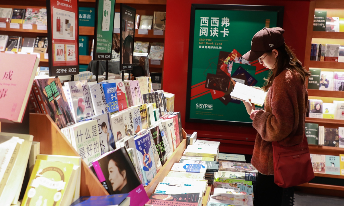 A customer checks out a book in a Shanghai bookstore. Photo: IC