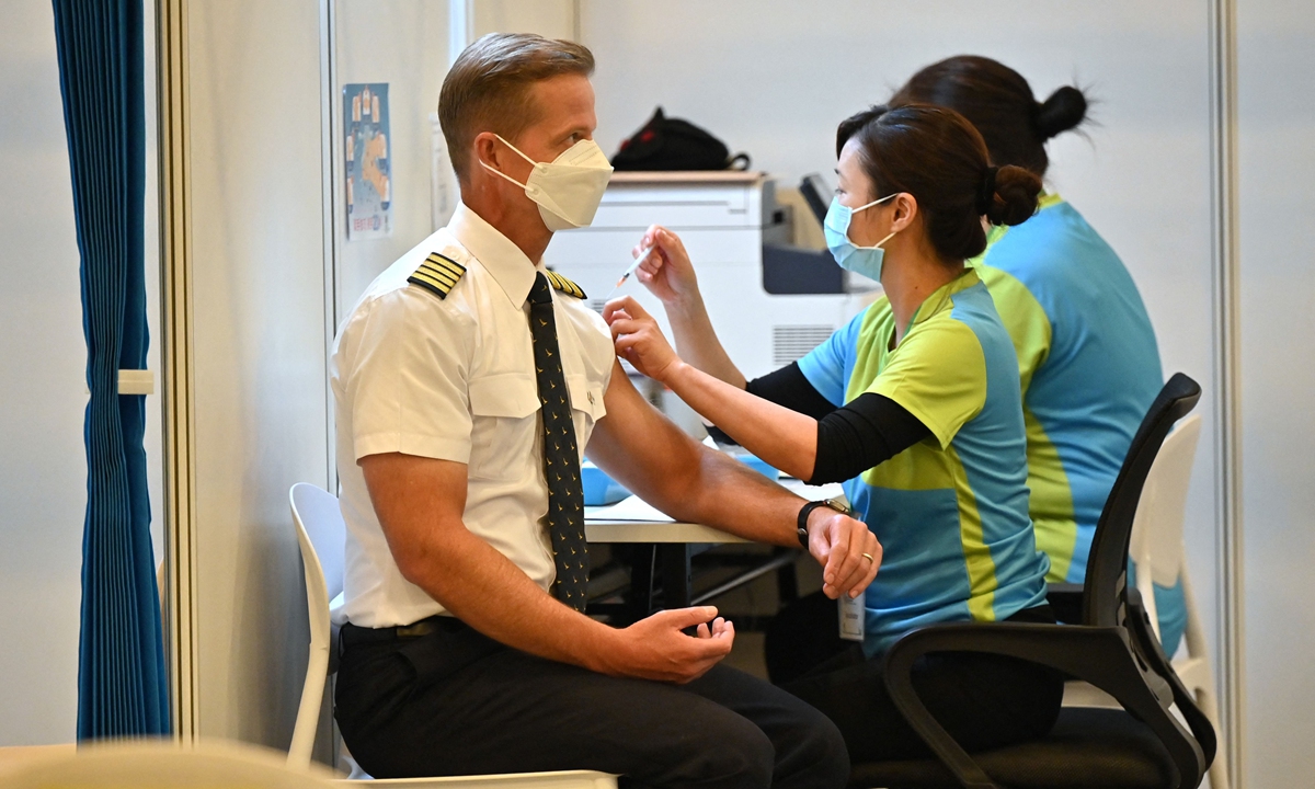 A Cathay Pacific pilot gets the Sinovac COVID-19 vaccine at a community vaccination center in the Hong Kong Central Library on Tuesday, as frontline workers and high-risk groups are the first in line to be vaccinated. Photo: VCG