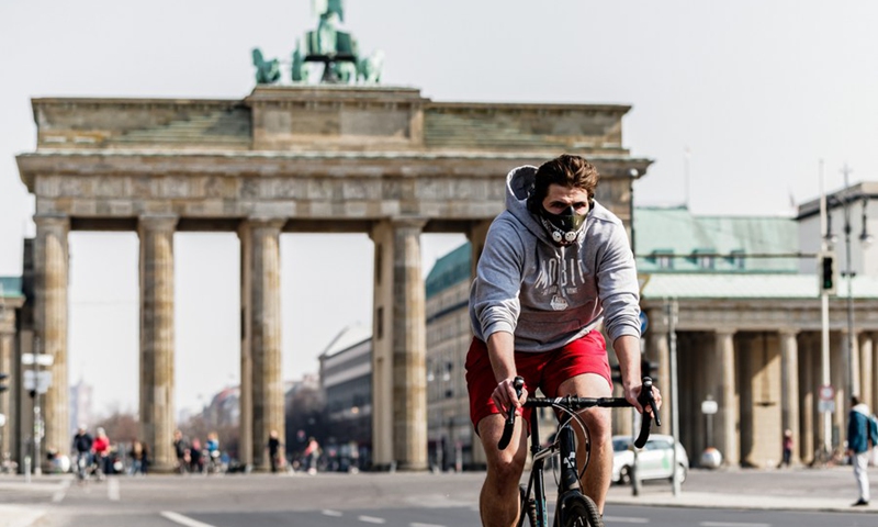 A cyclist wearing face mask is seen near the Brandenburger Gate in Berlin, capital of Germany, March 28, 2020.(Photo: Xinhua)