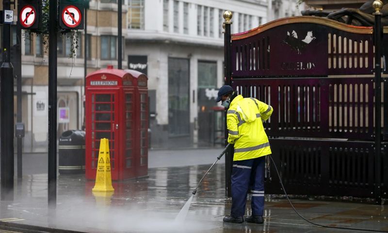 A worker cleans the road near Leicester Square in London, Britain, Dec. 21, 2020.(Photo: Xinhua)