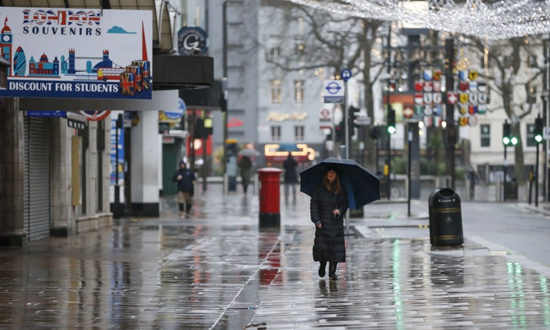 A woman walks on the street near Leicester Square in London, Britain, Dec. 21, 2020.(Photo: Xinhua)