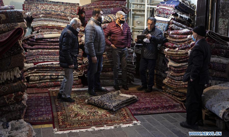 People buy hand-woven carpets at an old carpet bazaar in downtown Tehran, Iran, Feb. 27, 2021.(Photo: Xinhua)
