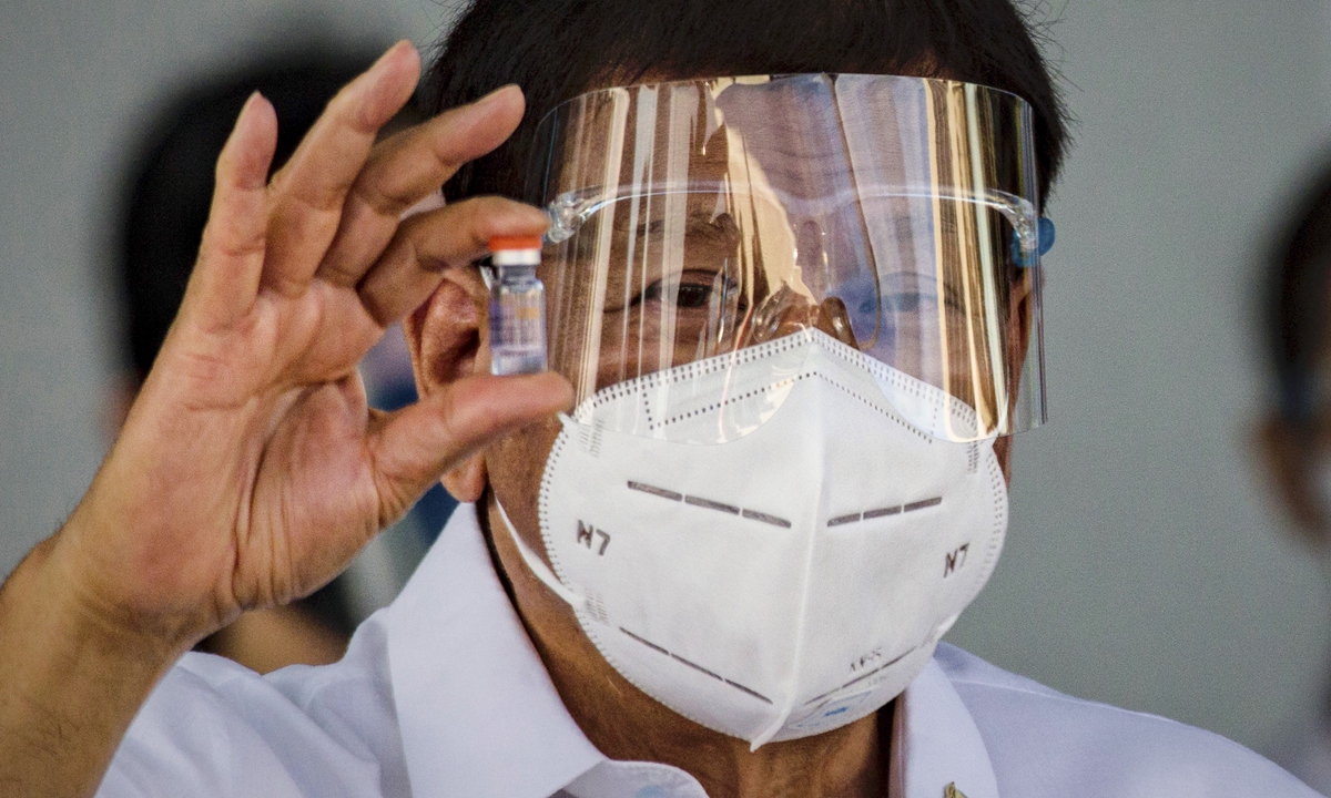 Philippine President Rodrigo Duterte holds up a vial of Sinovac Biotech's COVID-19 vaccine as he witnesses the arrival of a shipment of the vaccines, which were delivered by a Chinese military aircraft, at Ninoy Aquino International Airport on Sunday in Manila, Philippines. Photo: AFP