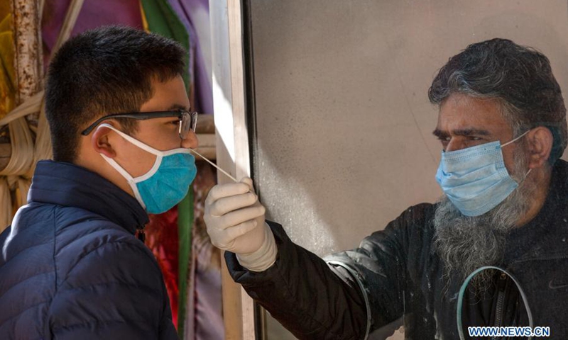 A health worker takes a nasal swab sample from a boy to test with Rapid Antigen Test (RAT) for the COVID-19 in Srinagar city, the summer capital of Indian-controlled Kashmir, Feb. 28, 2021.(Photo: Xinhua)