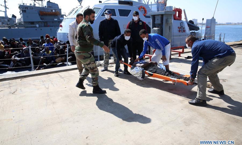 Workers carry an illegal immigrant at a naval base in Tripoli, Libya, on Feb. 28, 2021. A total of 181 illegal immigrants were rescued on Sunday by the Libyan Coast Guard off the country's western coast.(Photo: Xinhua)