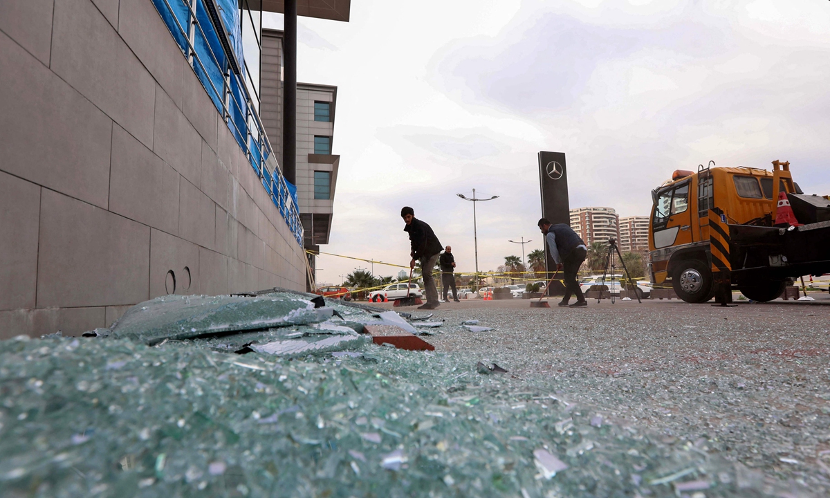 In this file photo taken on February 16, 2021 a worker cleans shattered glass outside a damaged shop following a rocket attack the previous night in Arbil, the capital of the northern Iraqi Kurdish autonomous region. Photo: VCG