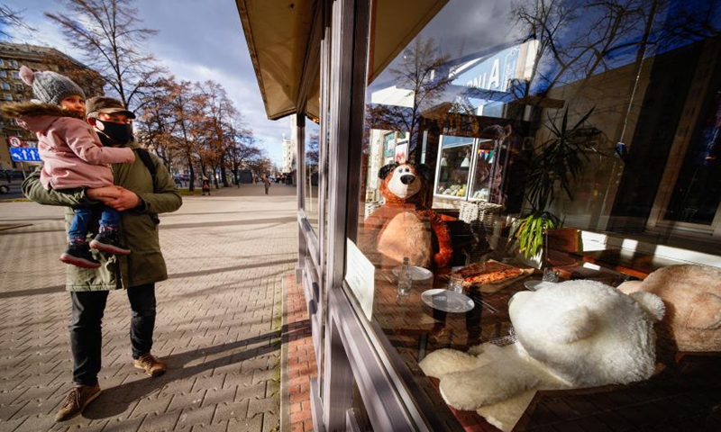 People walk past a pizza restaurant with stuffed toys seated at its empty tables in Warsaw, Poland, Feb. 27, 2021.Photo:Xinhua